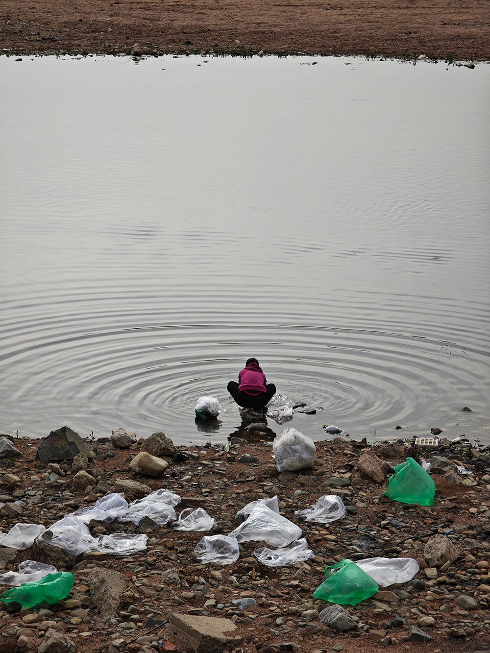 2025年4月16日,辽宁凤城二道河,清洗塑料袋的妇女