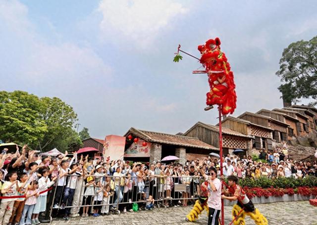 5月2日，在广东省佛山市禅城区南风古灶旅游休闲街区，游客在观看醒狮表演。新华社发（黄继明 摄）