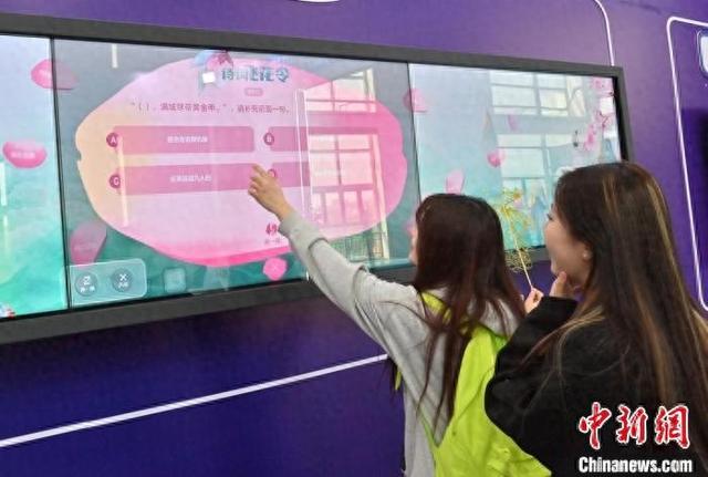 5月16日，吉林长春，读者在第二届东北书博会上与AI设备进行互动。 张瑶 摄