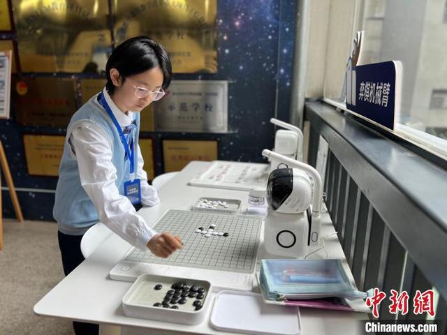 16日，南京市科利华中学学生手执黑子，与机器人棋盘对弈。中新网记者 朱晓颖 摄
