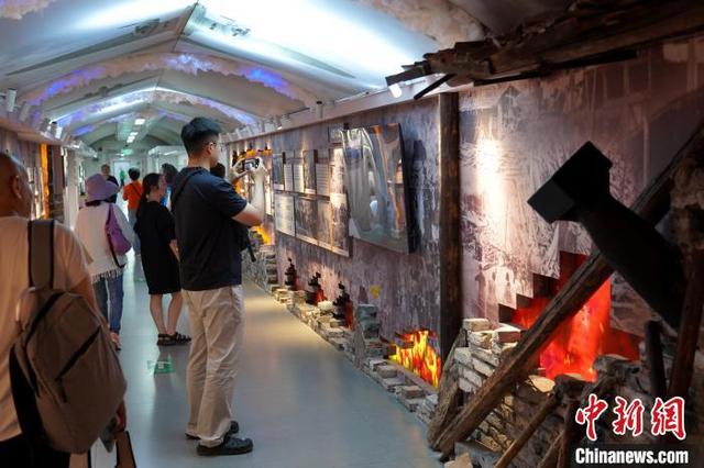 图为市民游客正在参观“一号防空洞”内的国防队员宣传墙。中新社记者 吕杨 摄