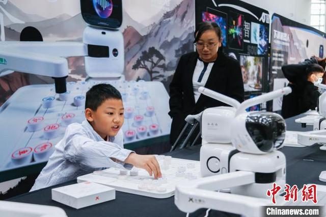 5月24日，青海西宁，小朋友对阵下棋机器人。中新社记者 马铭言 摄