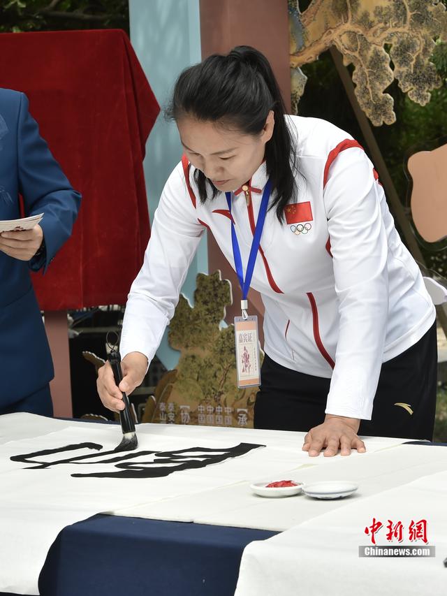 图为北京2008年奥运会女子柔道78公斤级冠军杨秀丽正在书写墨宝