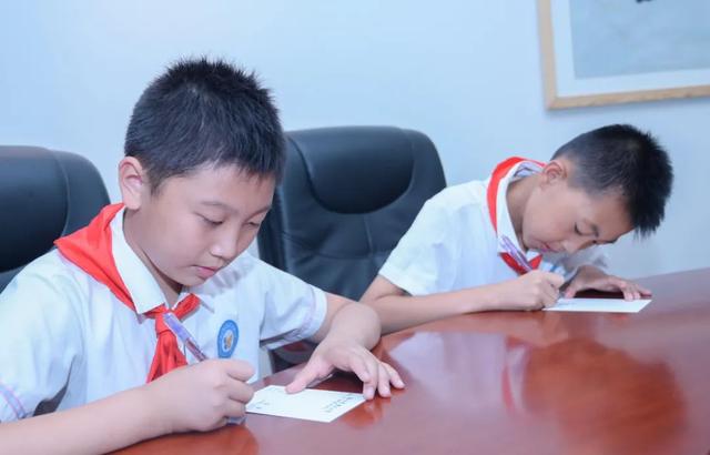 最后，学生们在法治明信片上写下自己的守法承诺和法治理想，依次排队投入法治信箱，相约明年六一回来查收自己的法治记忆。