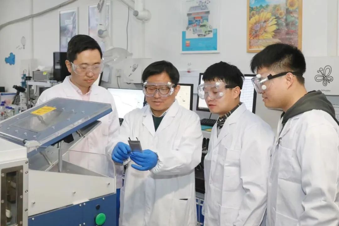 天津大学化工学院教授杨全红（中）在实验室与学生讨论研究进展。