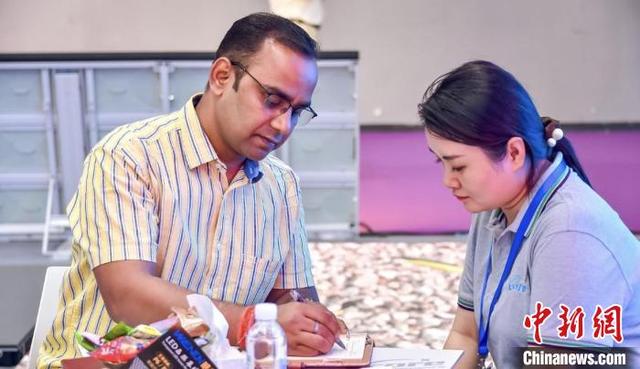 5月29日，海外采购商在第23届广州国际专业灯光、音响展览会上与中国商家洽谈。展会方 供图