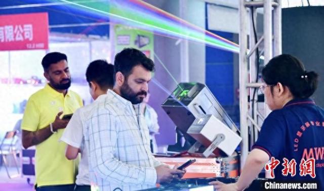 5月29日，海外采购商在第23届广州国际专业灯光、音响展览会上与中国商家洽谈。展会方 供图