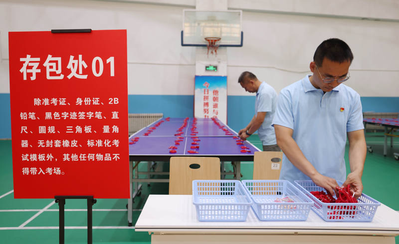 北京市第十九中学考点工作人员正在存包处整理摆放手环。新京报记者 李木易 摄