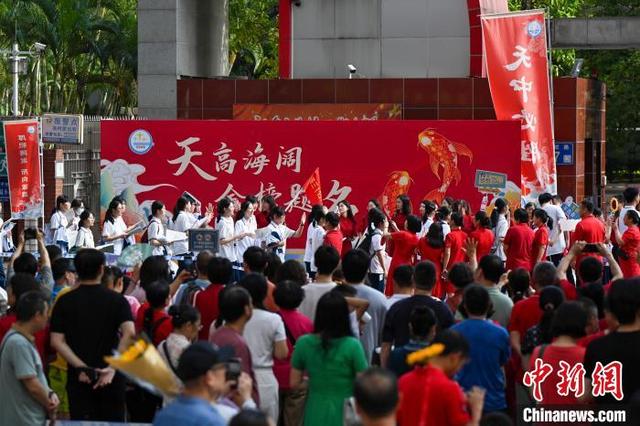 6月7日，考生家长与老师在广州天河中学考点外给考生加油打气。当日，2025年高考大幕开启。中新社记者 陈骥旻 摄