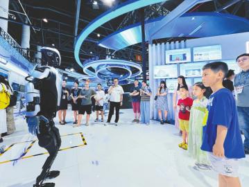 參觀者圍觀“綿陽造”人形機器人。 郭超英 攝
