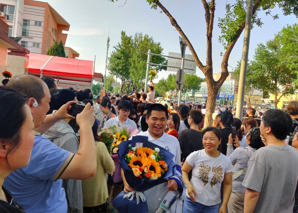 6月10日下午5时许,北京昌平二中回龙观校区考点外,手捧鲜花的考生们