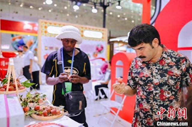 观众在“疆品南下 粤品北上”主题展区品尝广东荔枝。广东省对口支援新疆工作前方指挥部 供图