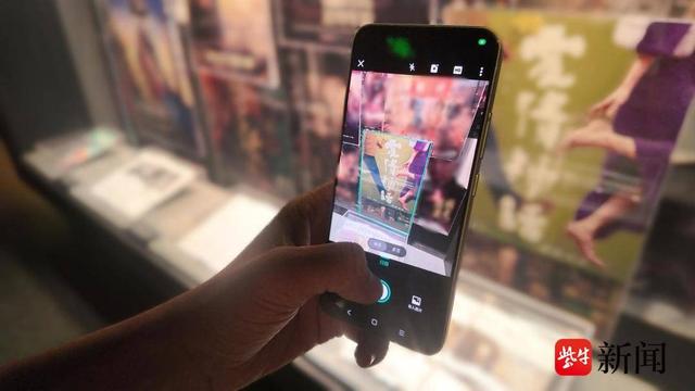 参观者用“智能高清滤镜”功能对《爱情神话》海报图像进行切边矫正