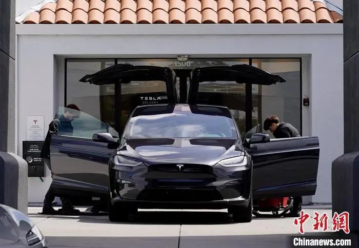 当地时间4月15日，美国加州圣马特奥县一家特斯拉电动车销售店的工作人员清洁一辆特斯拉电动车。 中新社记者 刘关关 摄