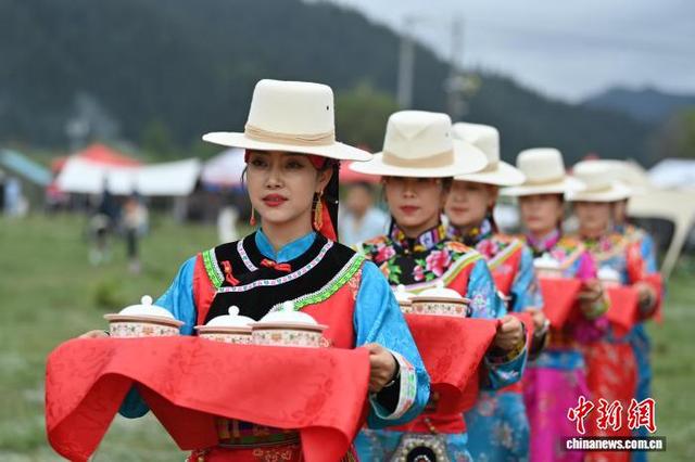 图为身穿“三格毛”的藏族姑娘为百岁老人端“藏王宴”菜品。 九美旦增 摄