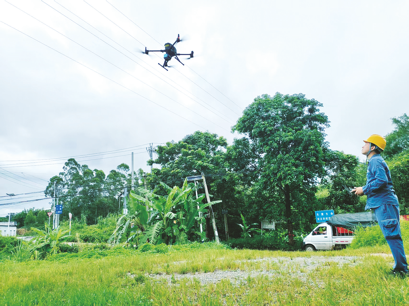     野外巡检工作人员操控无人机从高空对输变配线路进行巡检和影像信息采集。 本报记者朱新韬 摄