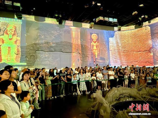 图为观众在《乐动敦煌》剧场内观看由声、光、电、影、音和真人演员组成的演出。王牧雨 摄