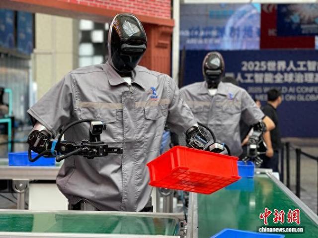 7月25日，在即将开幕的2025世界人工智能大会展厅里，人形机器人在“工业流水线”上作业。中新社记者 郑莹莹 摄