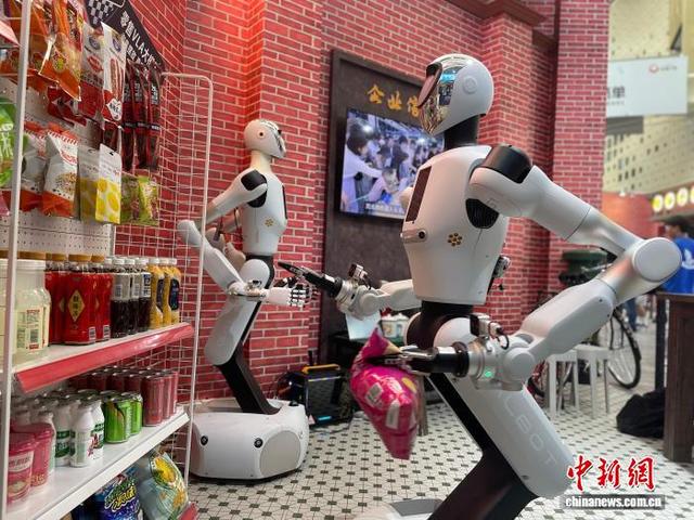 7月25日，在即将开幕的2025世界人工智能大会展厅里，人形机器人在“小卖部”里抓取商品。中新社记者 郑莹莹 摄
