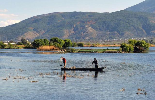 2014年2月19日，两名白族渔民在云南省大理白族自治州洱源县西湖国家湿地公园劳作。新华社记者蔺以光摄