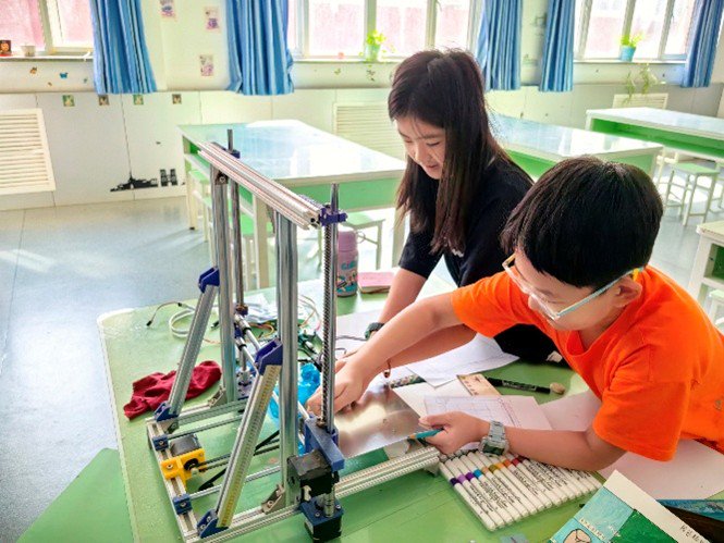 孩子们正在动手制作智能升降书包柜模型。（受访者供图）
