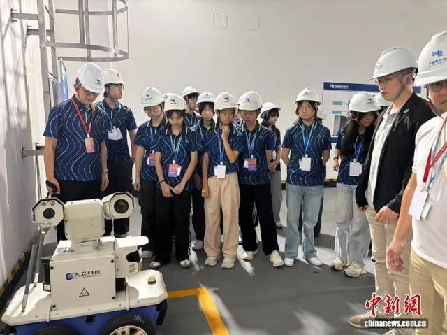 图为考察团成员了解智能巡检机器人的功能。何跃跃 摄