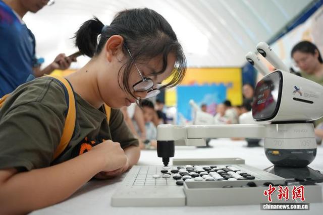 图为围棋机器人与青少年对弈。 吴敏 摄