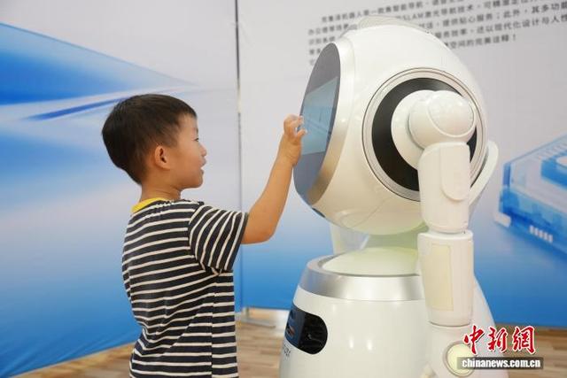图为儿童与AI机器人互动。 吴敏 摄