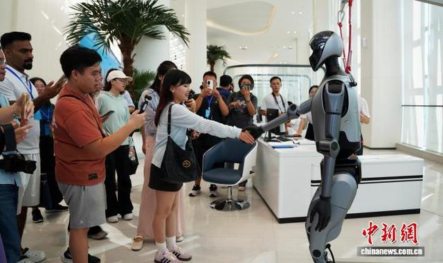 图为媒体记者在与机器人互动。中新网记者 黄艳梅 摄