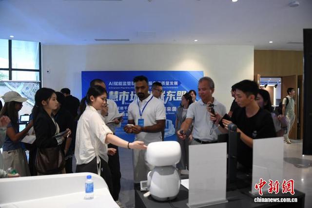 图为主流媒体代表、外籍网络达人了解智能机器人产品性能。林浩 摄