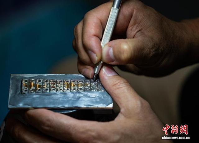 图为一位参展商现场展示手工雕刻装饰表带。中新网记者 侯宇 摄
