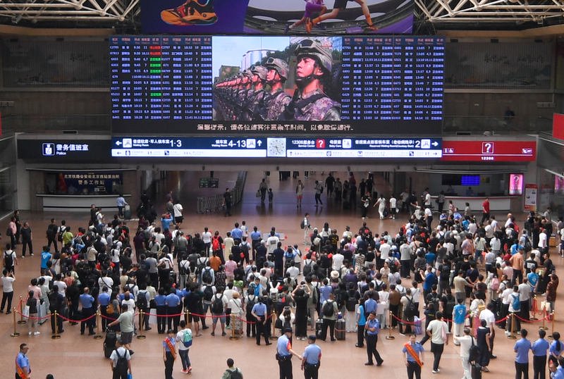 9月3日，北京西站大屏转播中央电视台直播，众多旅客停下脚步观看。新京报记者 王贵彬 摄