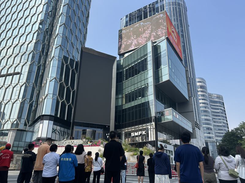 三里屯通盈中心广场前，人们仰望大屏，观看直播。新京报记者 陈琳 摄