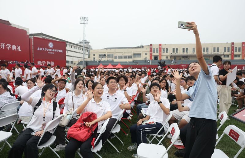 新生在开学典礼现场拍照留念。新京报记者 李木易 摄