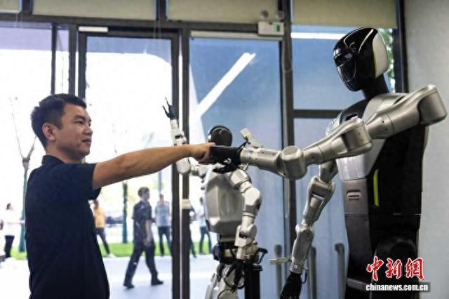 近日，2025互联网岳麓大会上，一位参观者与人形机器人互动。中新网记者 唐小晴 摄