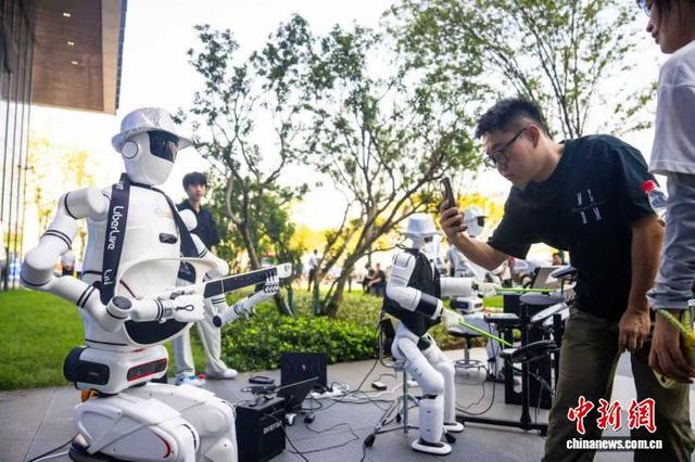 近日，一位参观者在2025互联网岳麓大会上拍摄乐队机器人。中新网记者 唐小晴 摄
