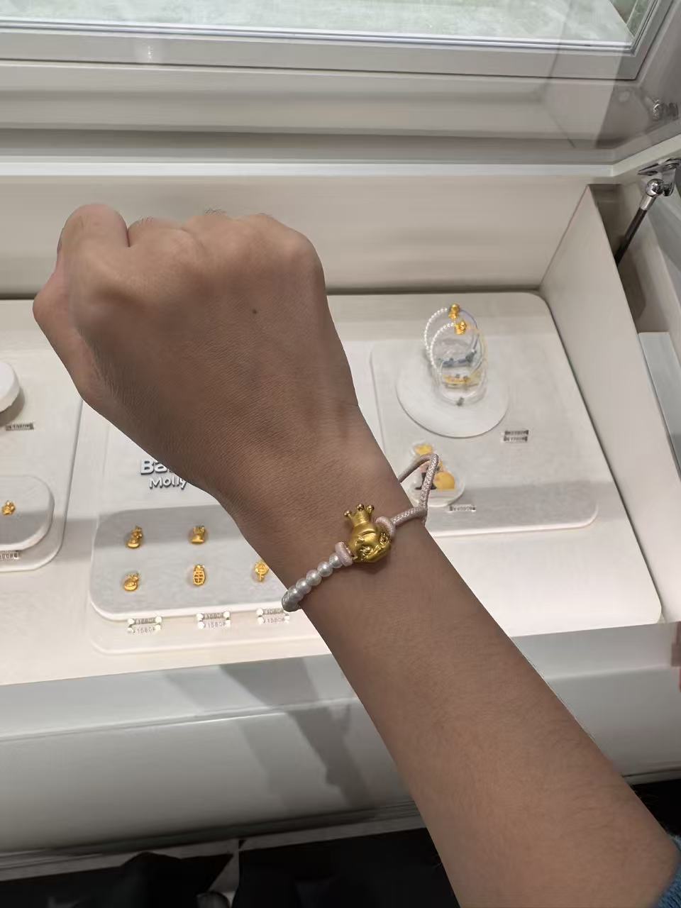 （记者试戴Molly黄金串珠产品，来源：21世纪经济报道记者拍摄）