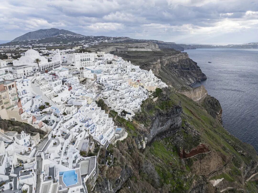资料图：希腊圣托里尼岛陡峭的火山悬崖。（图片来源：视觉中国）