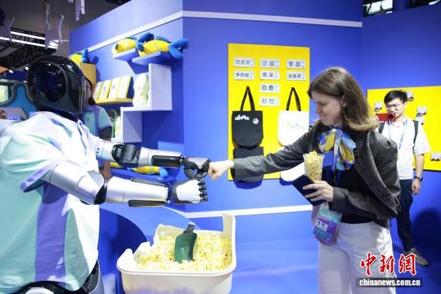 9月25日，第四届全球数贸会主题展区，国际客商与现场展出的人形机器人互动。孙杨洋 摄