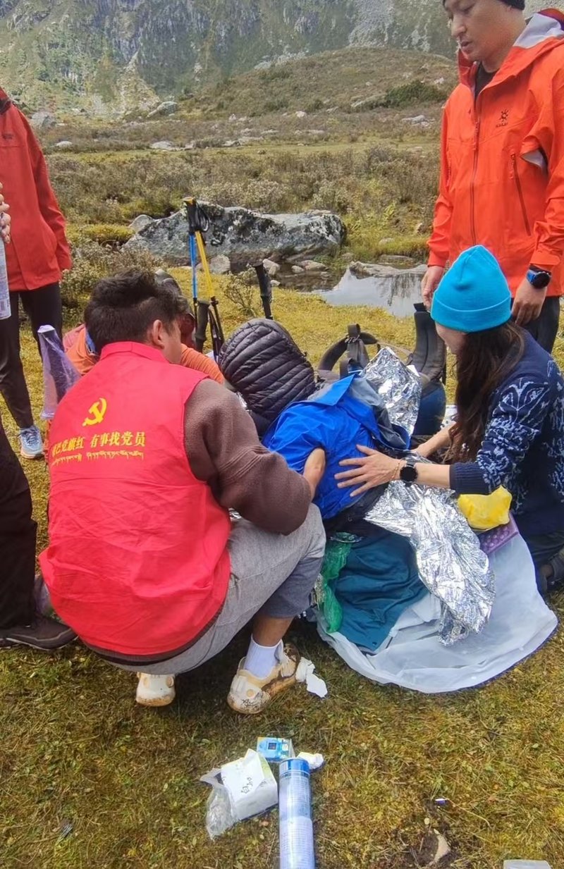 丹东镇政府工作人员拉马加和路过的游客一起帮女孩披上保温毯。 受访者供图