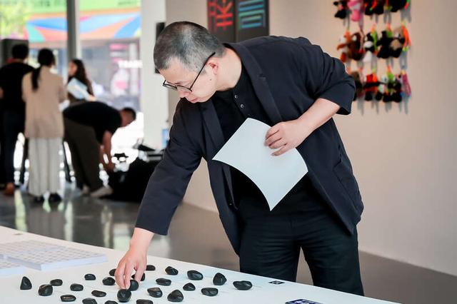 展览现场，项目负责人蒋华教授在做开幕式前最后的整理工作。中央美术学院设计学院供图