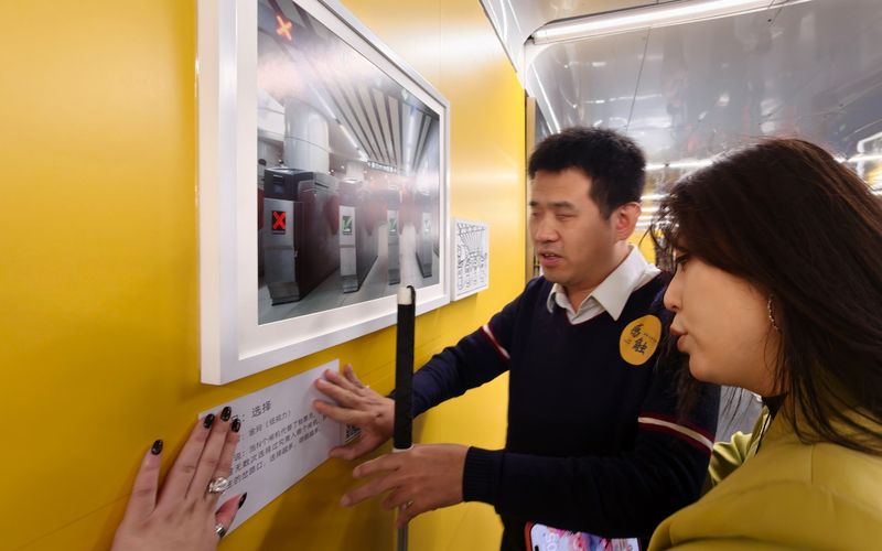 盲人摄影师杨青风通过触摸了解展出作品。新京报记者 王贵彬 摄
