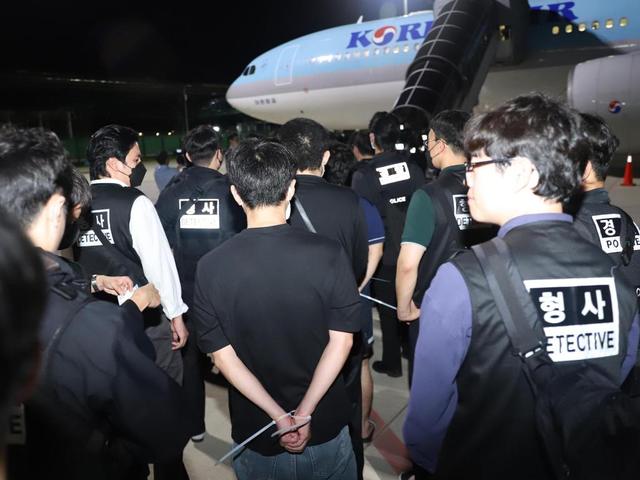 當?shù)貢r間2025年10月18日凌晨，在柬埔寨金邊德崇國際機場，警察押送被遣返的韓國網(wǎng)絡詐騙嫌疑人登機。新華社 圖