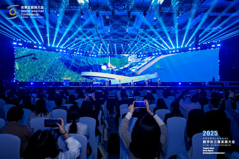 2025年数字长三角发展大会现场，7个人形机器人与场下观众挥手致意。主办方供图