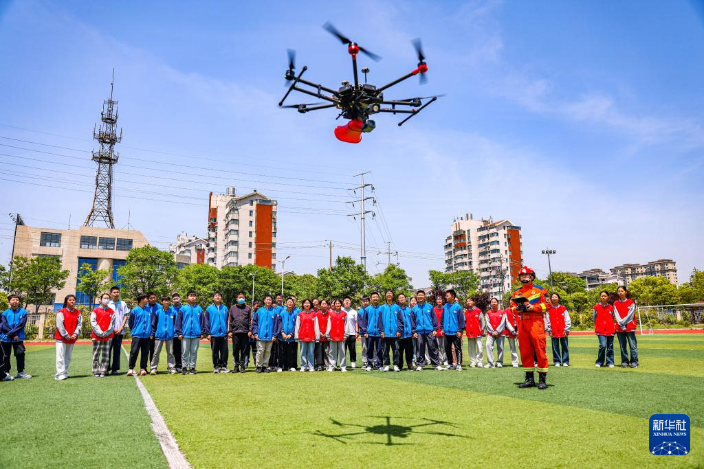 2025年5月12日，扬州市江都区消防救援大队消防员在给中学生演示消防职业技能。新华社发（任飞 摄）