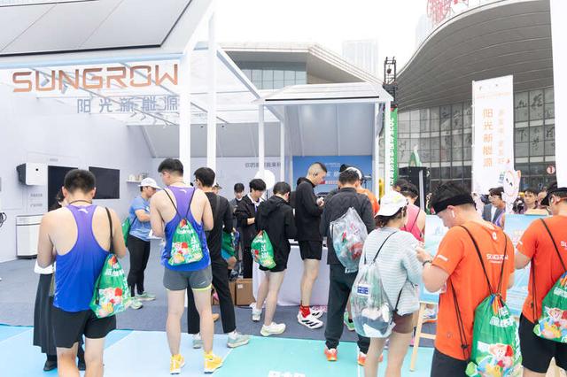 图为参赛选手在手机充能站体验“绿电充电”。钱文静/摄