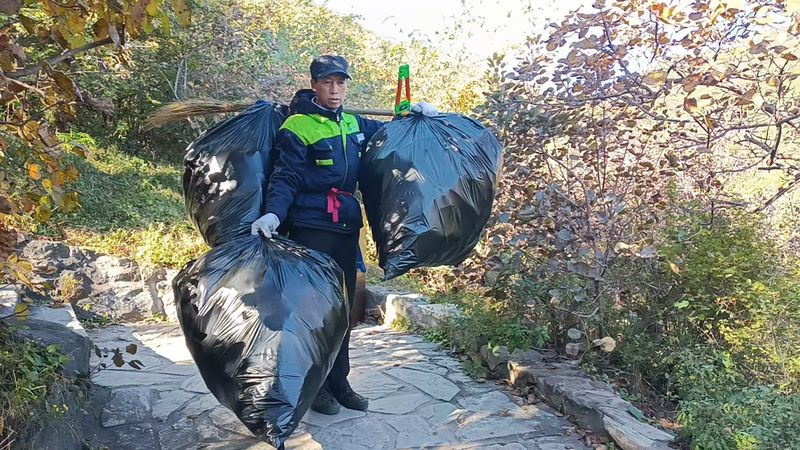 保洁人员人工背运垃圾。香山公园供图