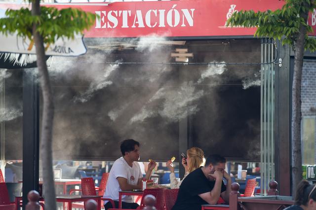 2025年9月17日，在西班牙馬德里，顧客在水霧裝置附近用餐。新華社發(fā)（古斯塔沃·巴連特攝）