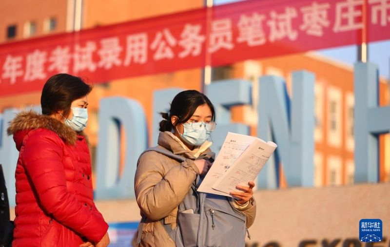 ▲在2025年度“国考”山东省枣庄市某考点，考生在入场前抓紧时间复习。图/新华社