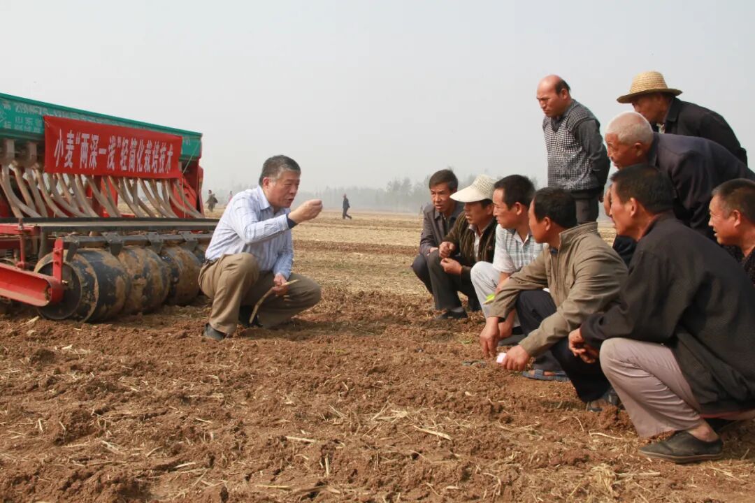 王法宏研究员在田间培训小麦播前播后镇压技术。